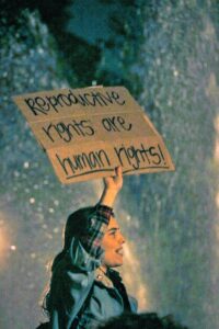 Woman holding a sign that says "Reproductive rights are human rights!"